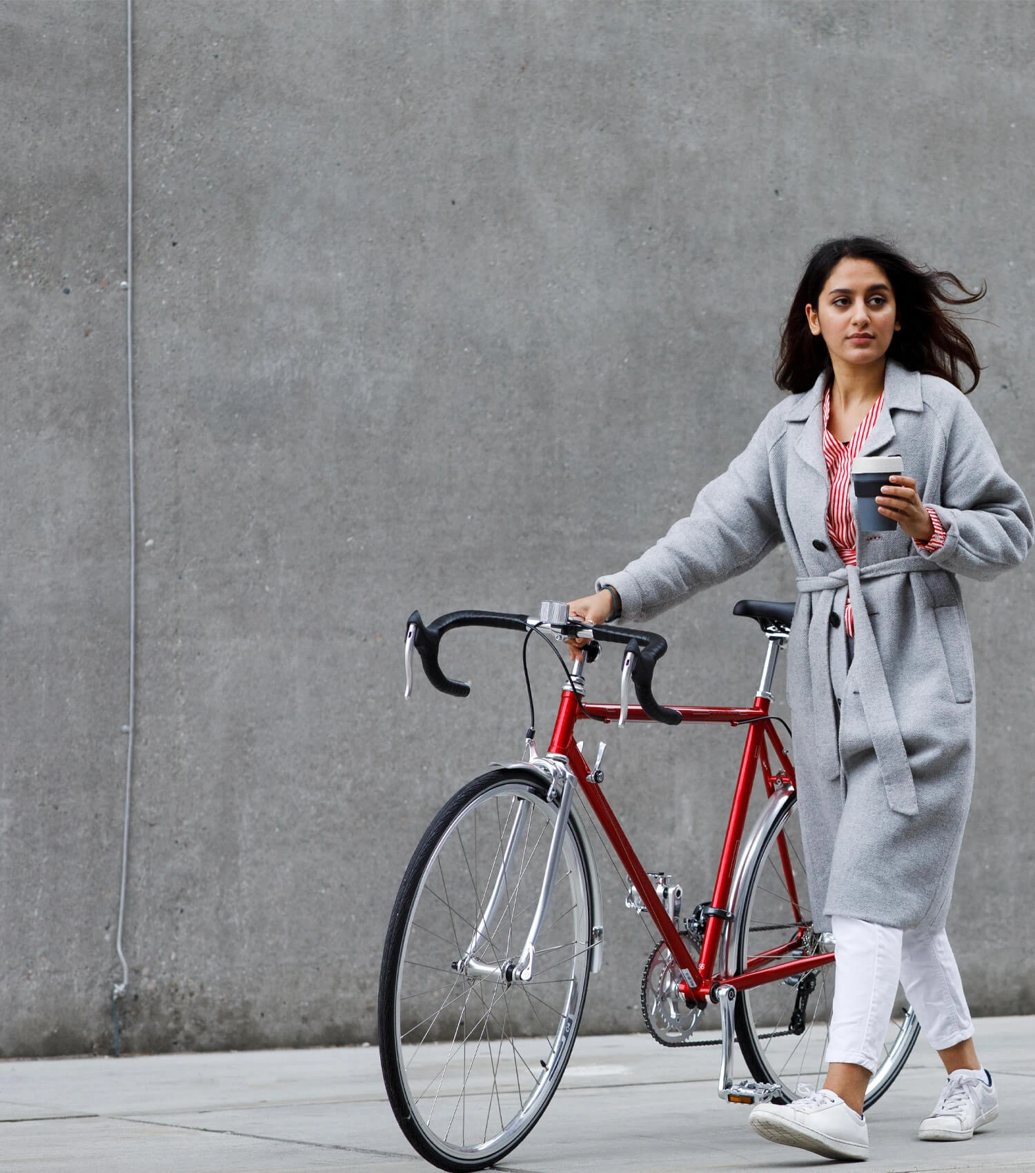 Une femme avec son vélo dans un environnement urbain
