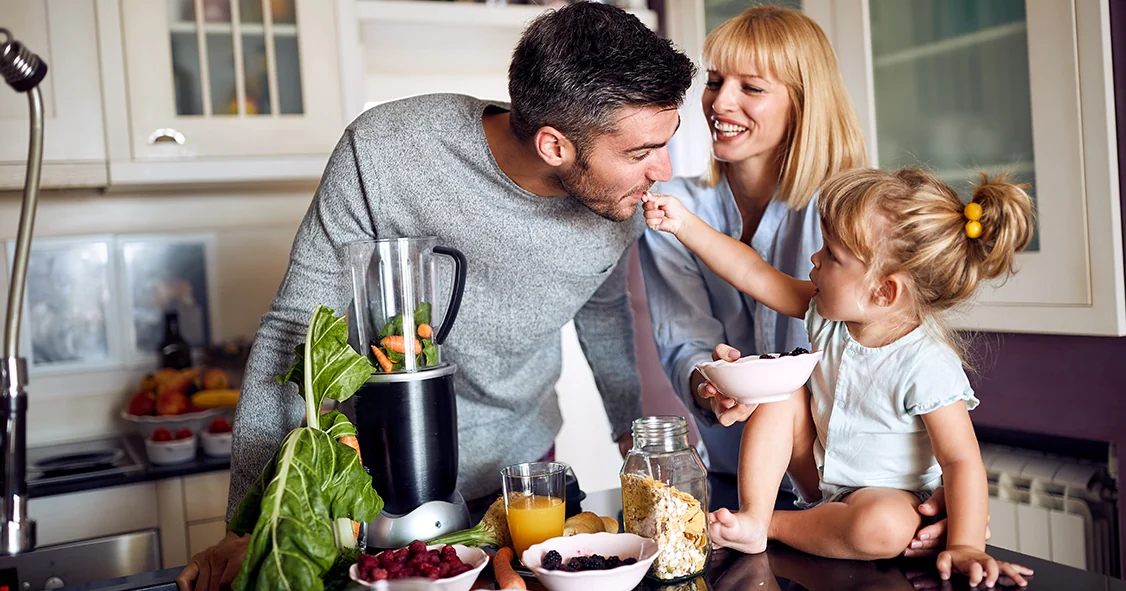 Une famille prépare une boisson et des aliments dans une cuisine